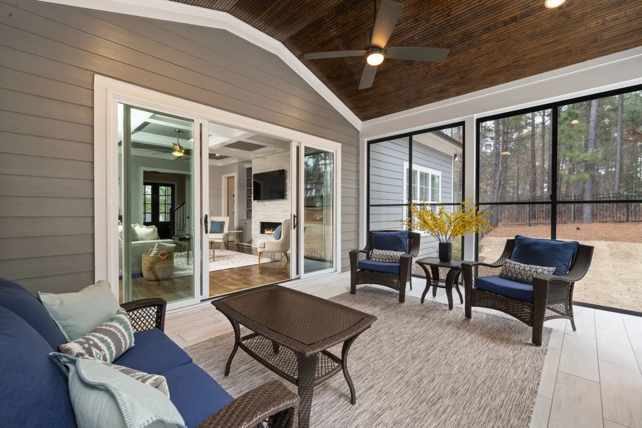 Bright enclosed porch with large screened windows and sliding patio doors